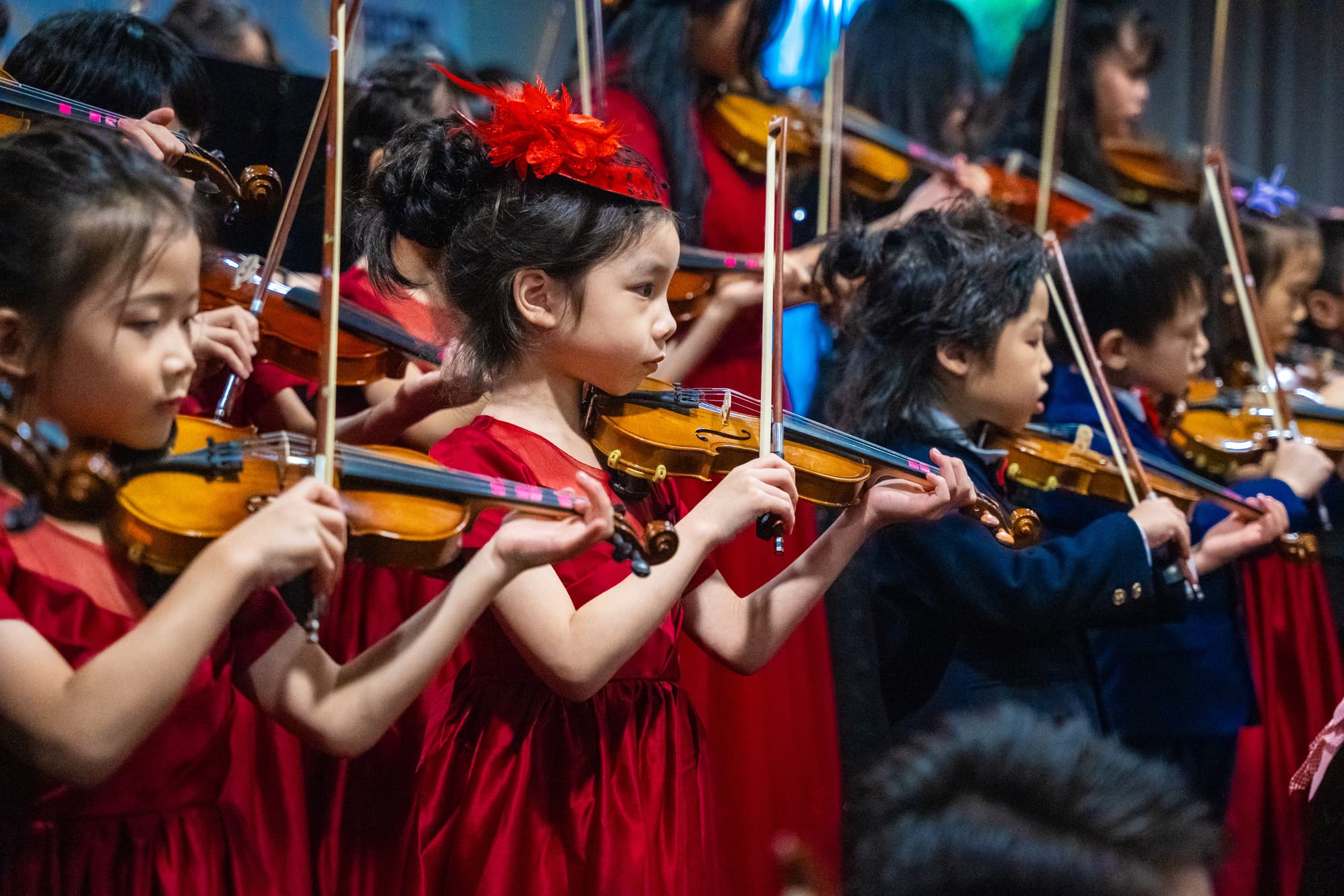 Young violinists performing together in a focused Claviera string ensemble.