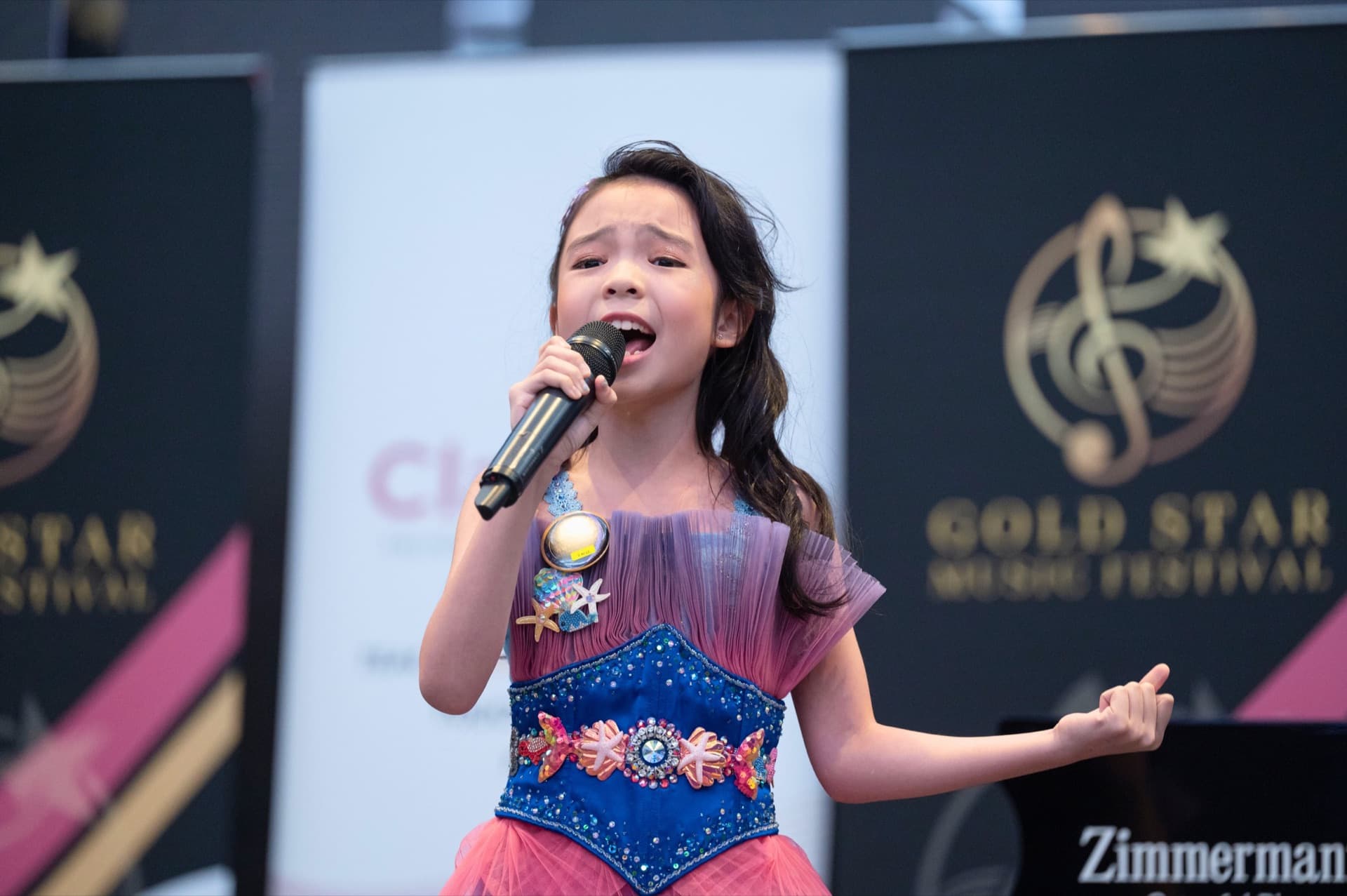 Young vocalist performing on a Claviera Music stage.