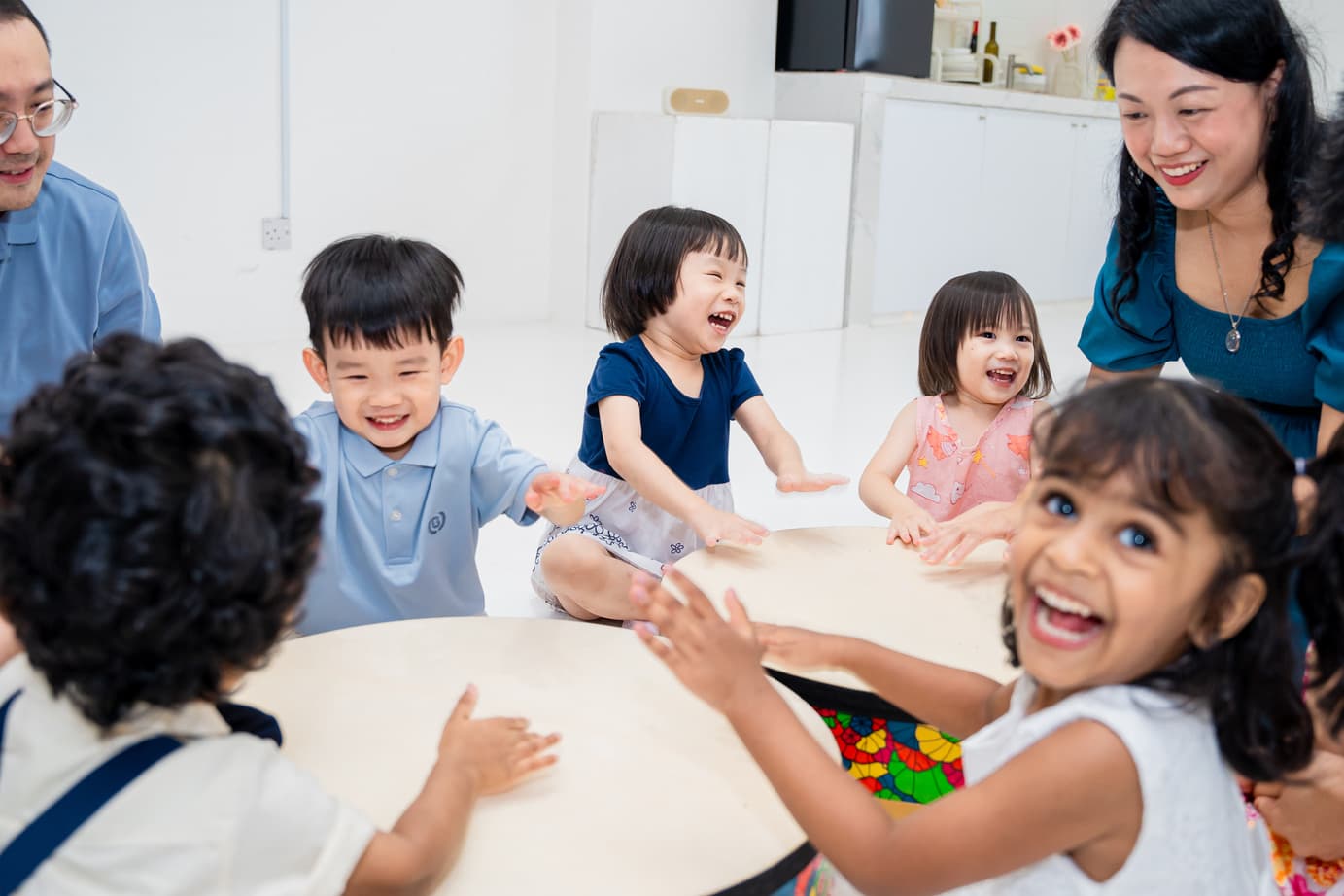 Young children smiling and participating together during a Claviera Petite music activity.
